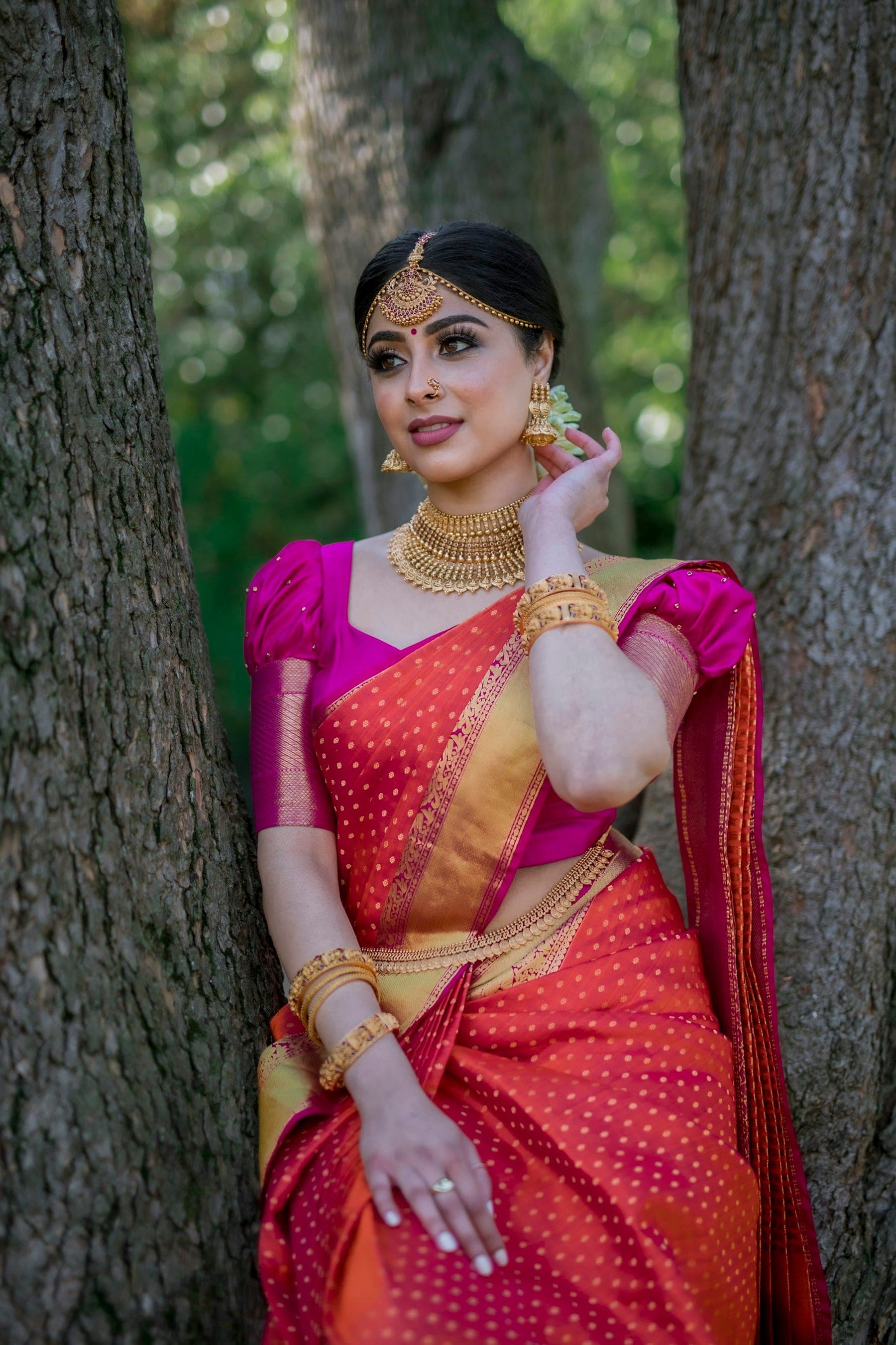 Woman in a red and pink silk saree with temple jewellery