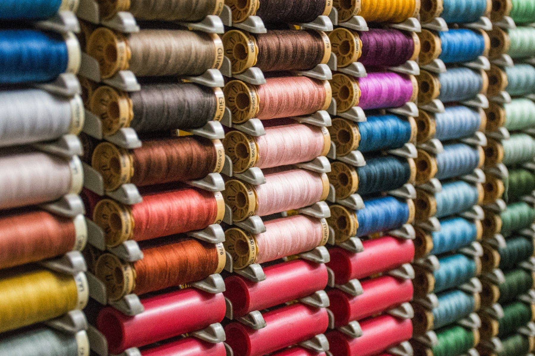 Rows of thread spools in warm and cool tones