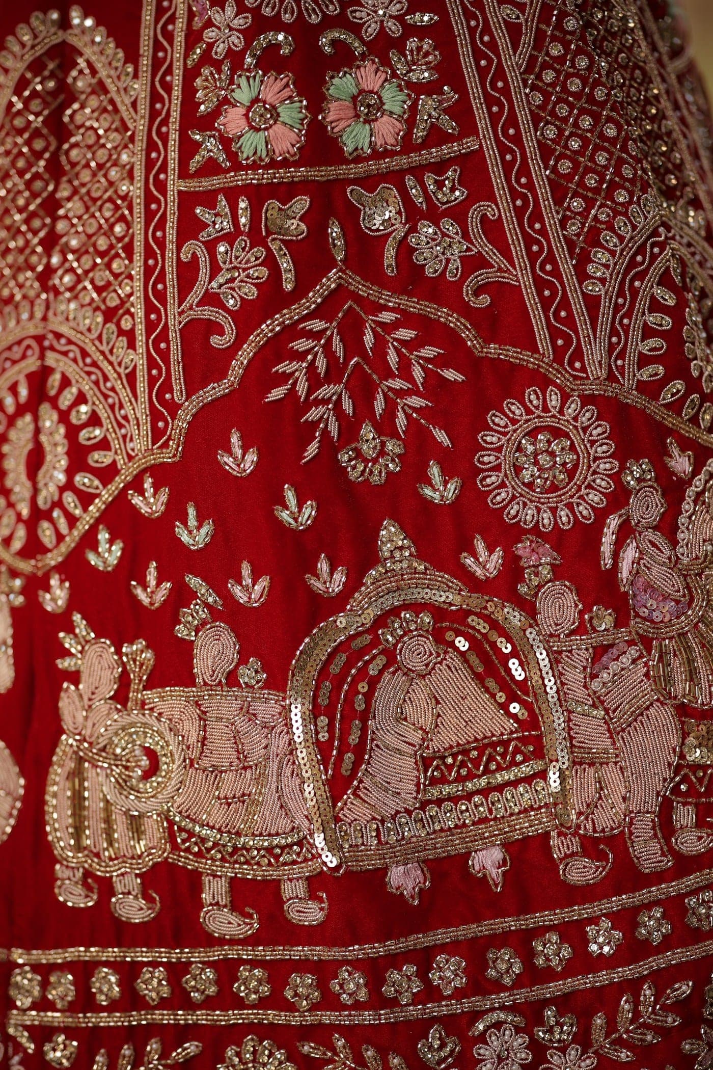 Close-up of hand embroidery on a red lehenga