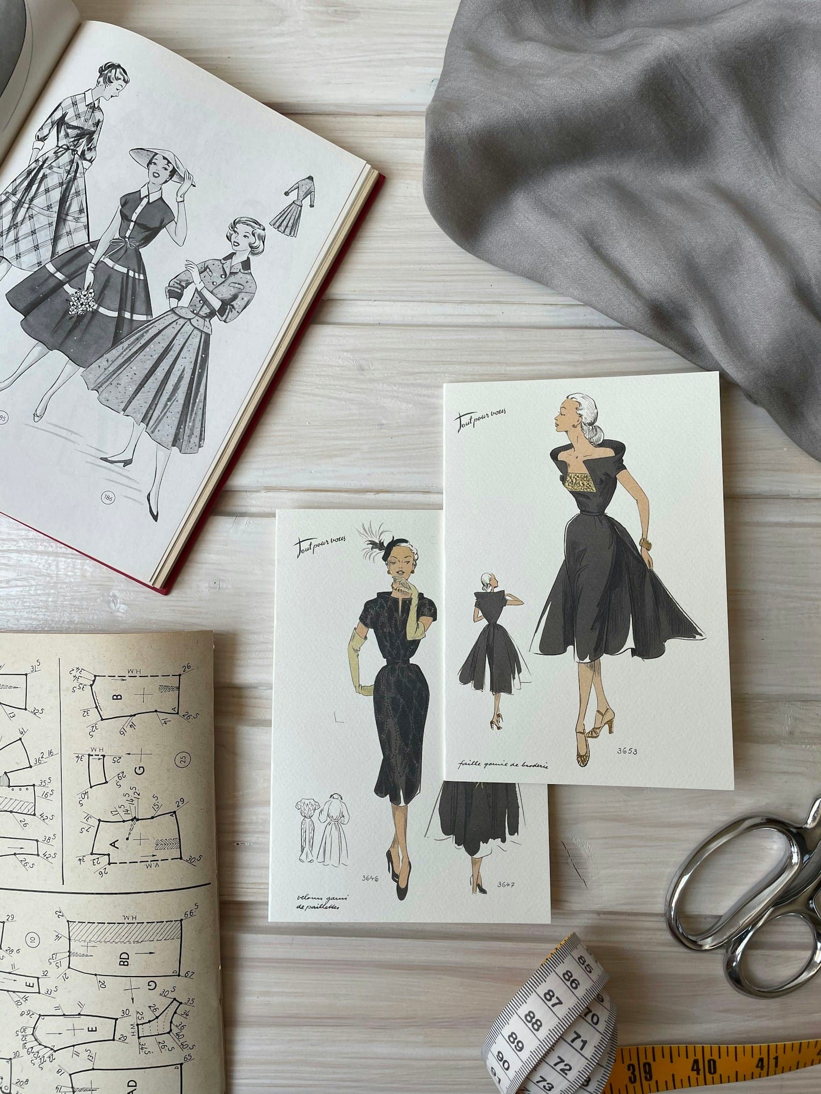 Vintage fashion sketches and pattern notes on a designer's table